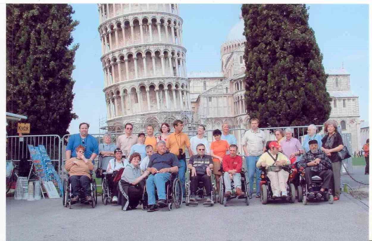 Das Foto zeigt eine Reisegruppe vor dem schiefen Turm von Pisa.