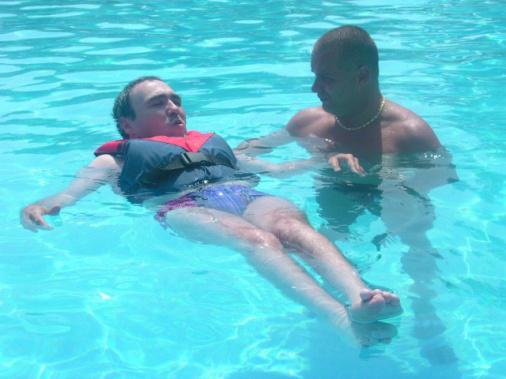 Das Foto zeigt einen Rollstuhlfahrer beim Schwimmunterricht.